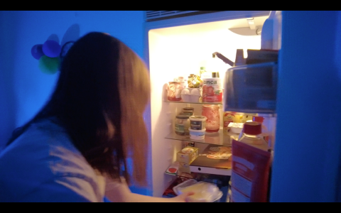 En person plockar ut mat från ett kylskåp