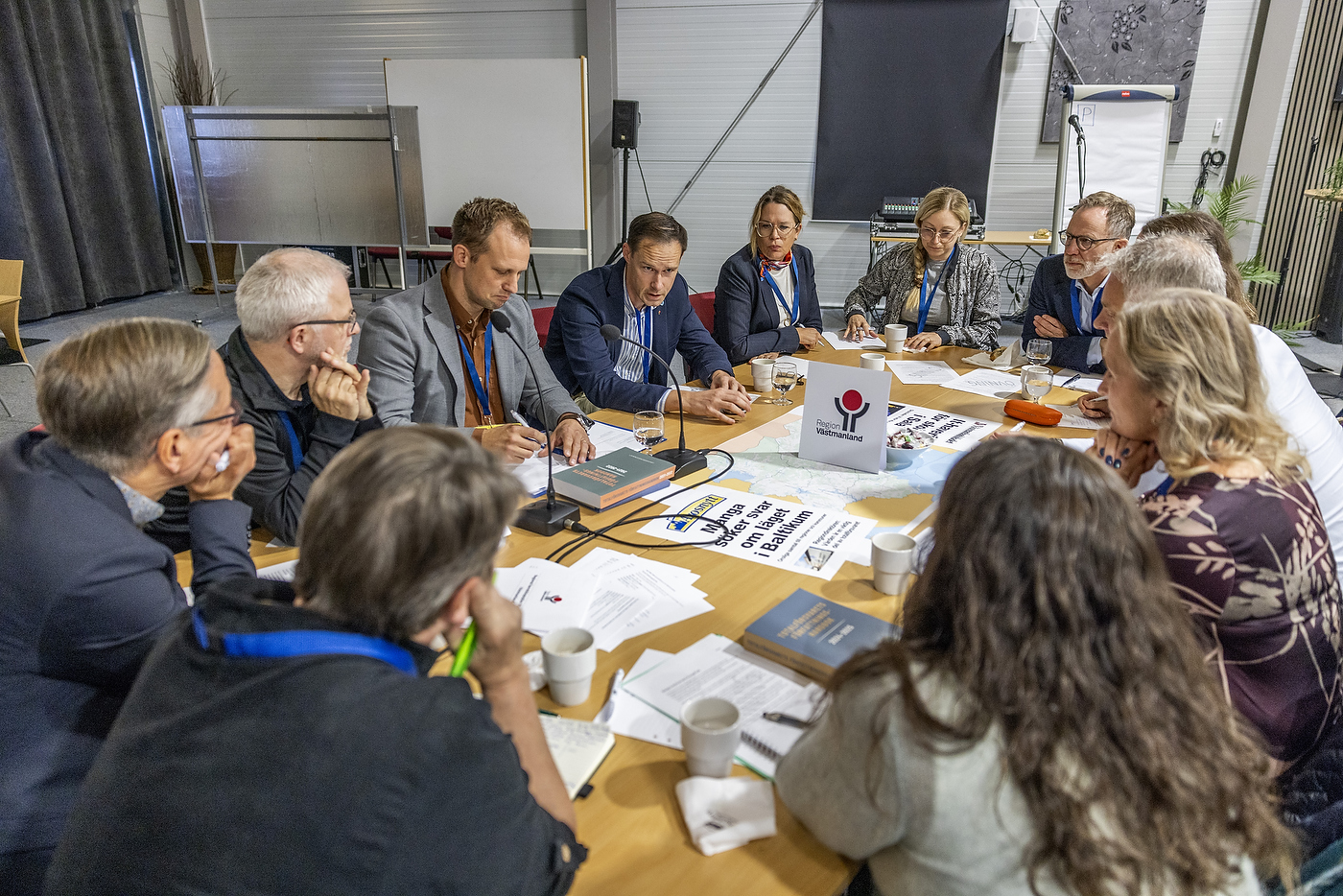 Stort konferensbord med ett tiotal deltagare.