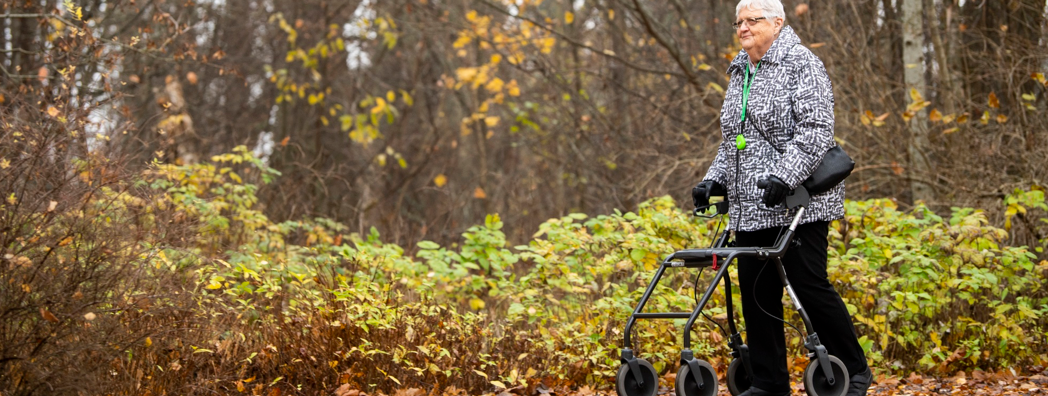 En kvinna går med rollator