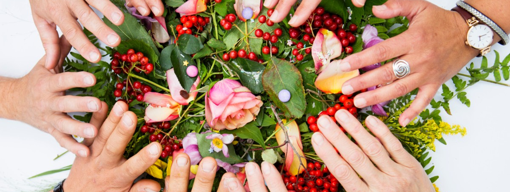 Många händer ovanför en bukett