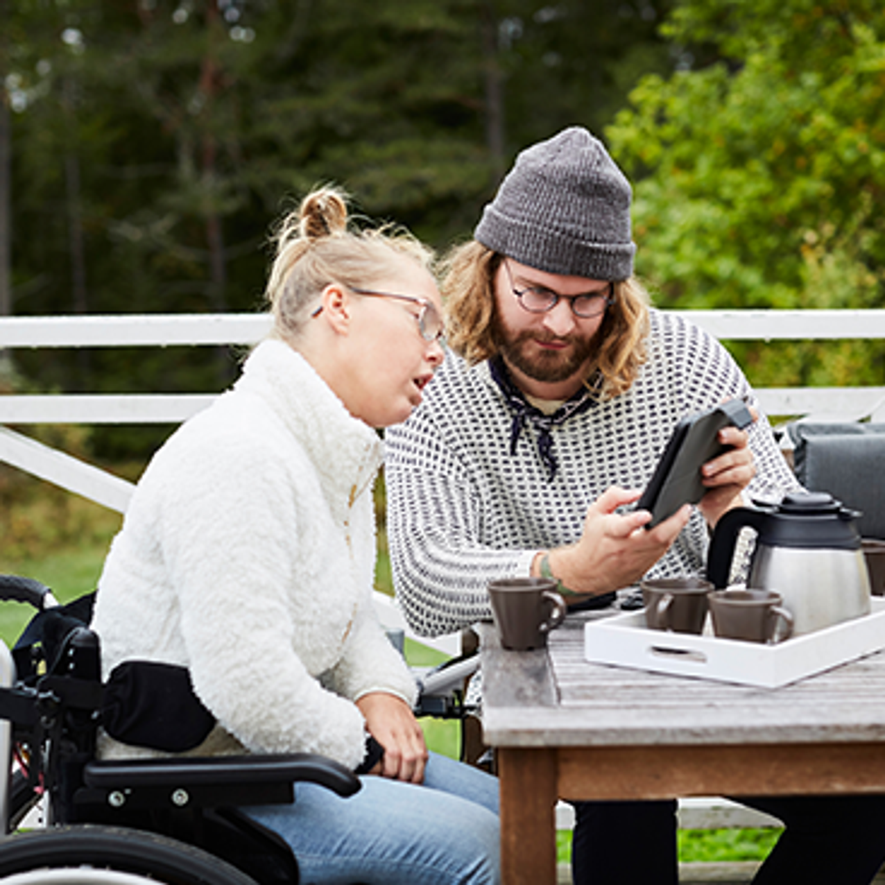 Glad äldre kvinna i grönskande trädgård