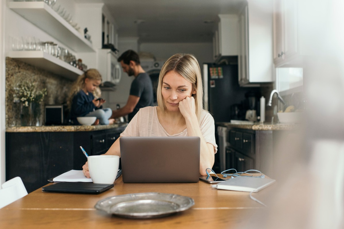 Person sitter med dator i köket