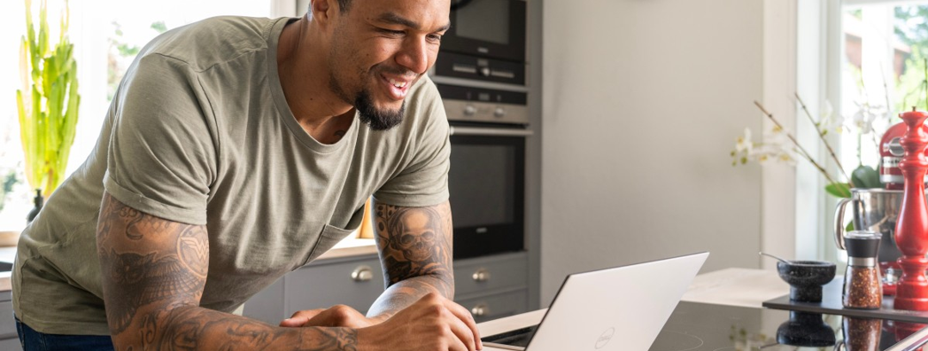 Man ståendes vid sin laptop i köket