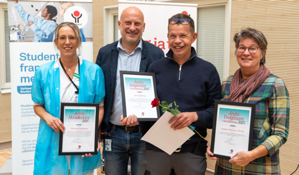 En grupp människor som står bredvid varandra och håller i plaketter.