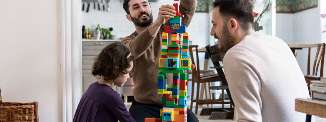 Två vuxna bygger lego med barn