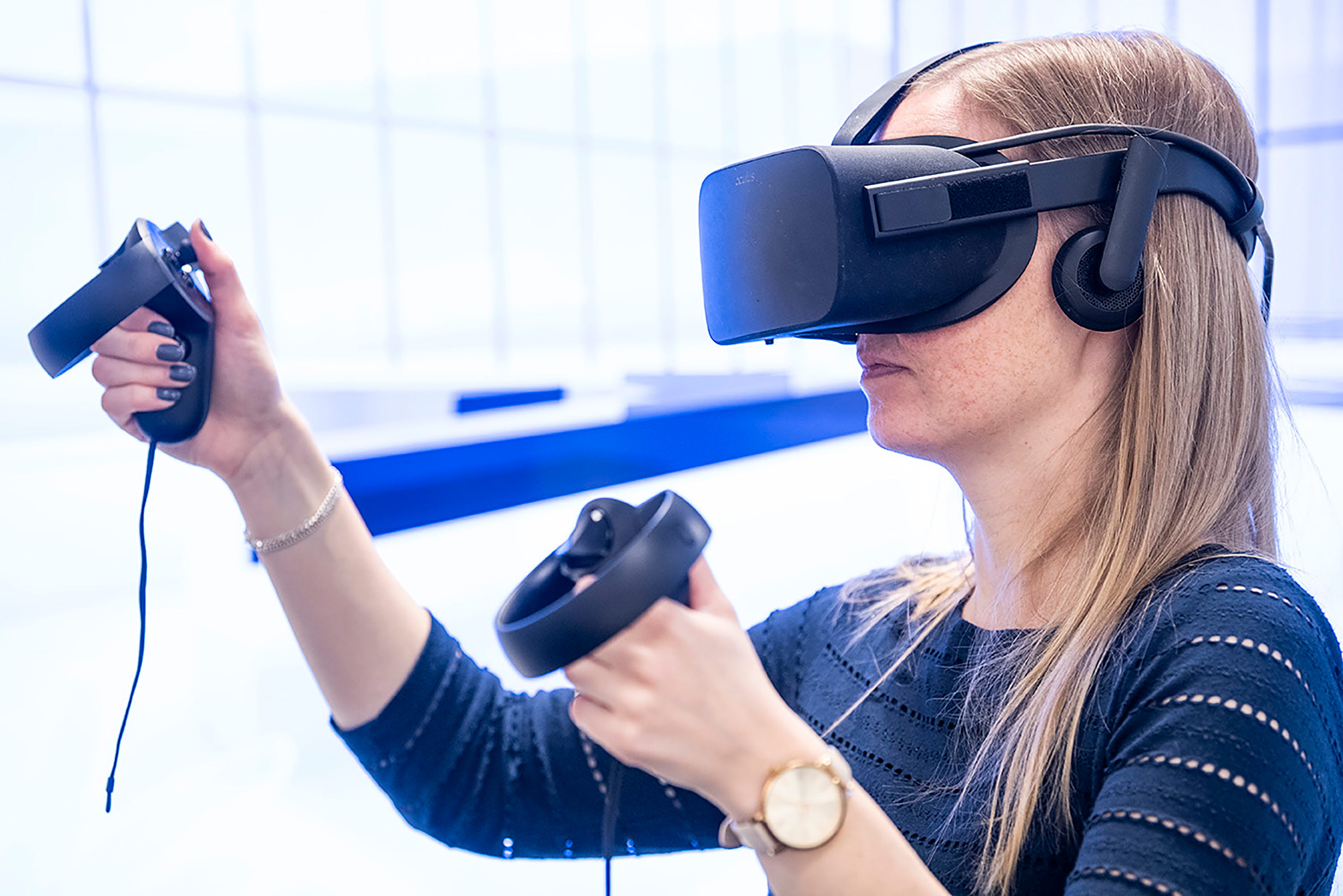 Ung kvinna i ljust rum provar VR-glasögon