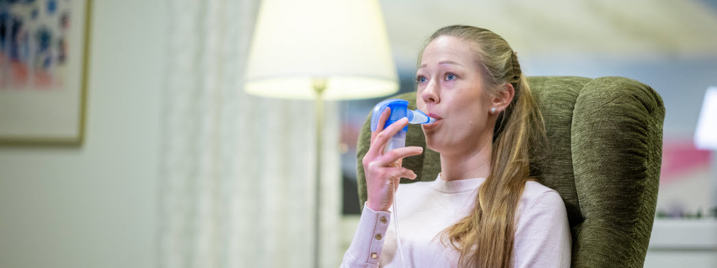 En kvinna andas med hjälp av en inhalator