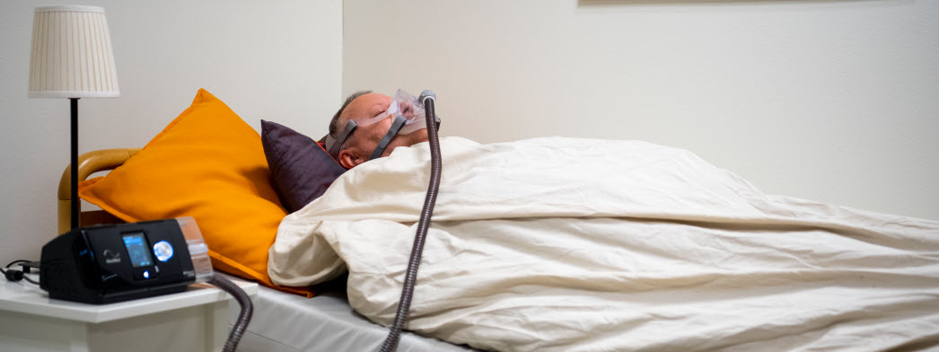 En man använder en CPAP-apparat när han sover