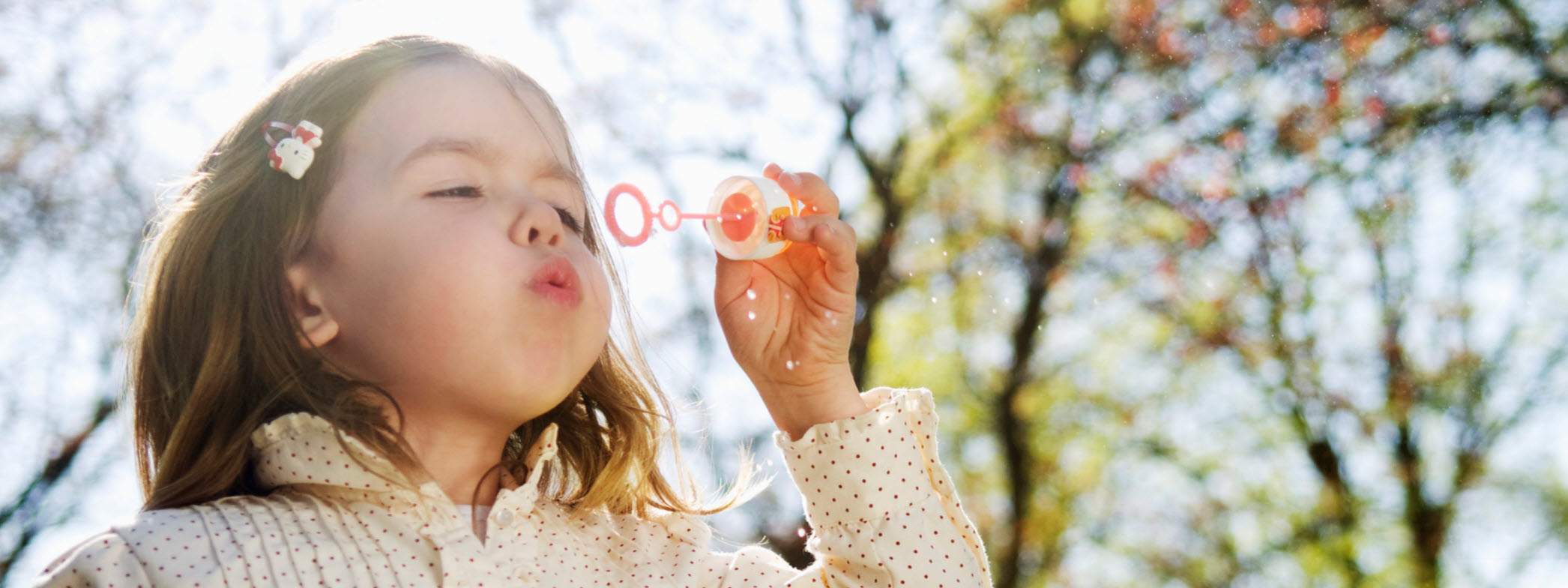 Barn blåser såpbubblor i sommarväder