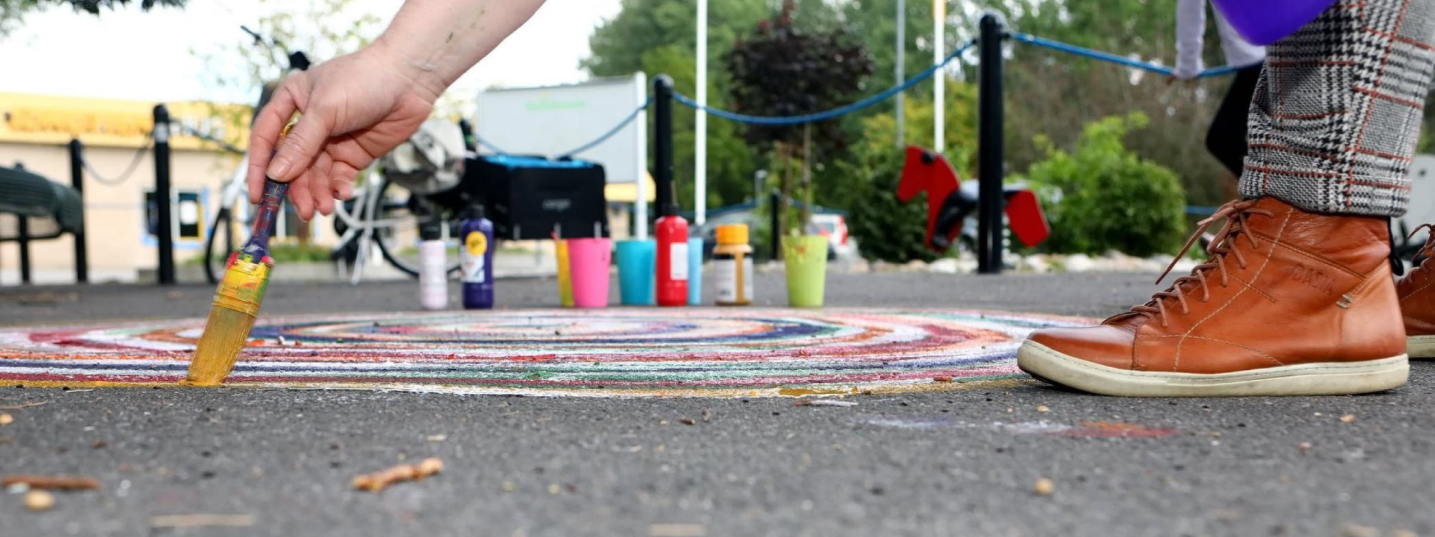 En person målar ett konstverk på asfalten