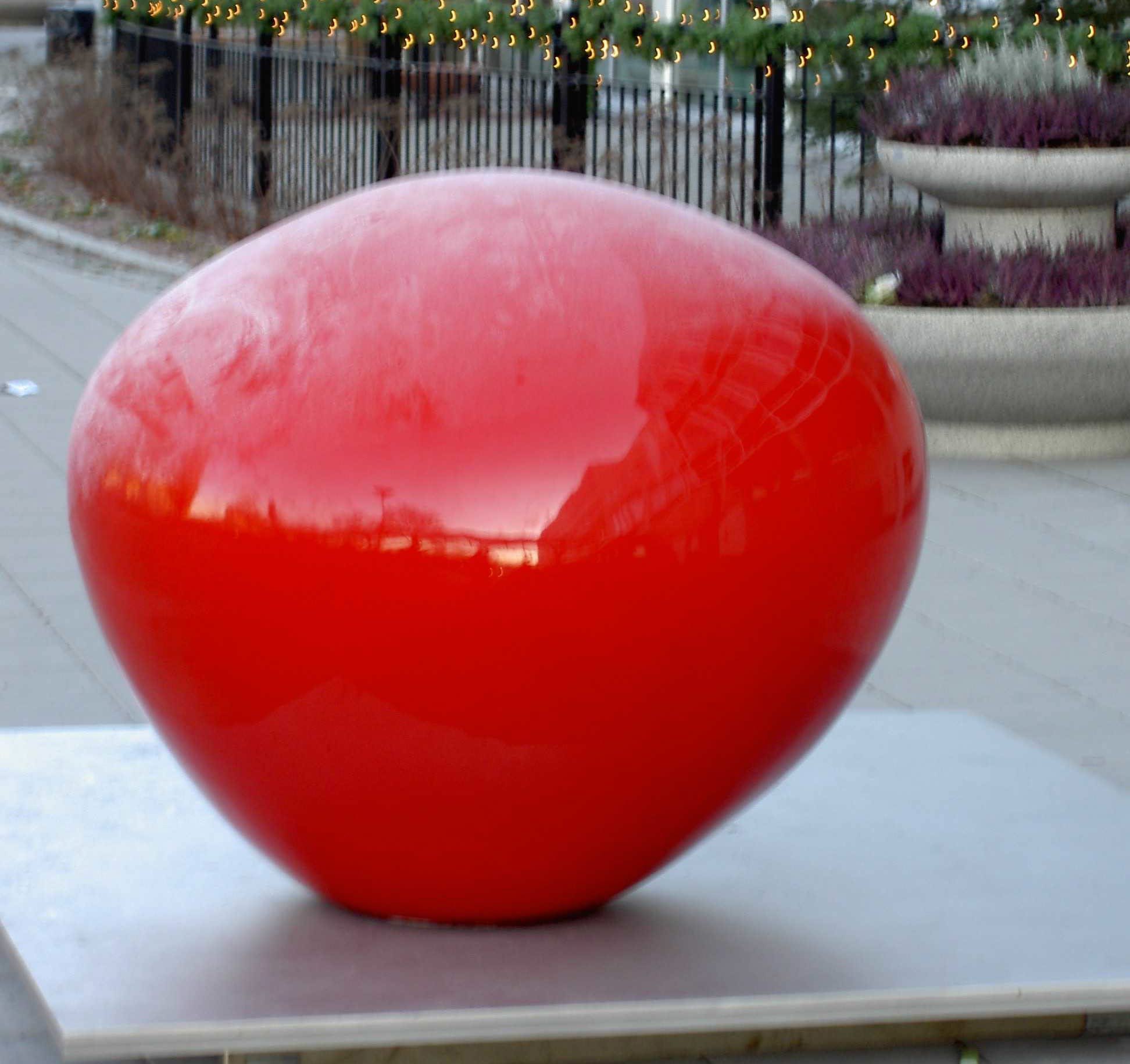 En röd skulptur som har formen av en droppe